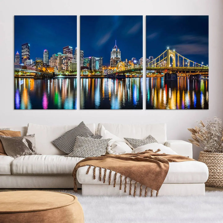 The living room features a gallery-wrapped triptych of Pittsburgh's skyline at night, reflecting on water. This Pittsburgh Skyline Canvas Wall Art is displayed above the cabinets and is printed on museum-quality canvas with a UV-protective coating to maintain its lasting vibrancy.