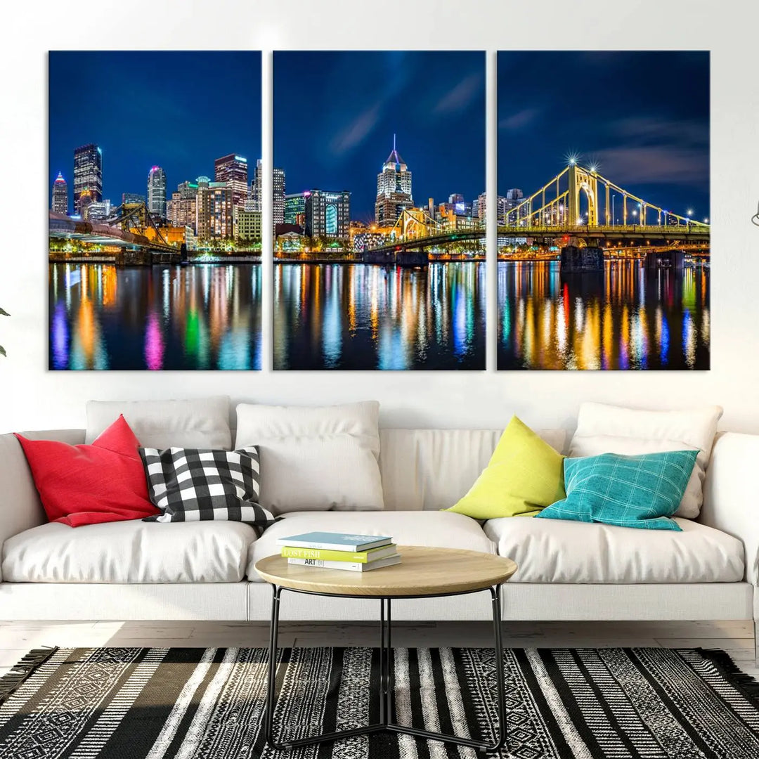 The living room features a gallery-wrapped triptych of Pittsburgh's skyline at night, reflecting on water. This Pittsburgh Skyline Canvas Wall Art is displayed above the cabinets and is printed on museum-quality canvas with a UV-protective coating to maintain its lasting vibrancy.