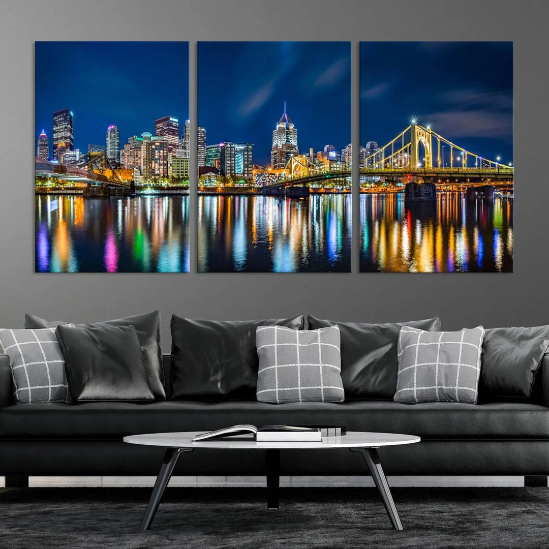 The living room features a gallery-wrapped triptych of Pittsburgh's skyline at night, reflecting on water. This Pittsburgh Skyline Canvas Wall Art is displayed above the cabinets and is printed on museum-quality canvas with a UV-protective coating to maintain its lasting vibrancy.