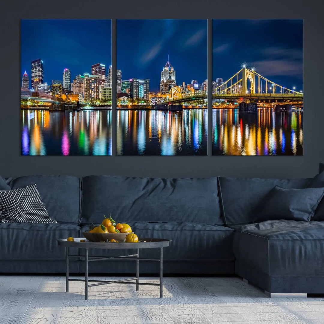 The living room features a gallery-wrapped triptych of Pittsburgh's skyline at night, reflecting on water. This Pittsburgh Skyline Canvas Wall Art is displayed above the cabinets and is printed on museum-quality canvas with a UV-protective coating to maintain its lasting vibrancy.