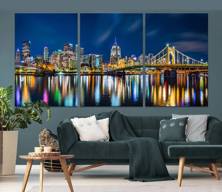 The living room features a gallery-wrapped triptych of Pittsburgh's skyline at night, reflecting on water. This Pittsburgh Skyline Canvas Wall Art is displayed above the cabinets and is printed on museum-quality canvas with a UV-protective coating to maintain its lasting vibrancy.