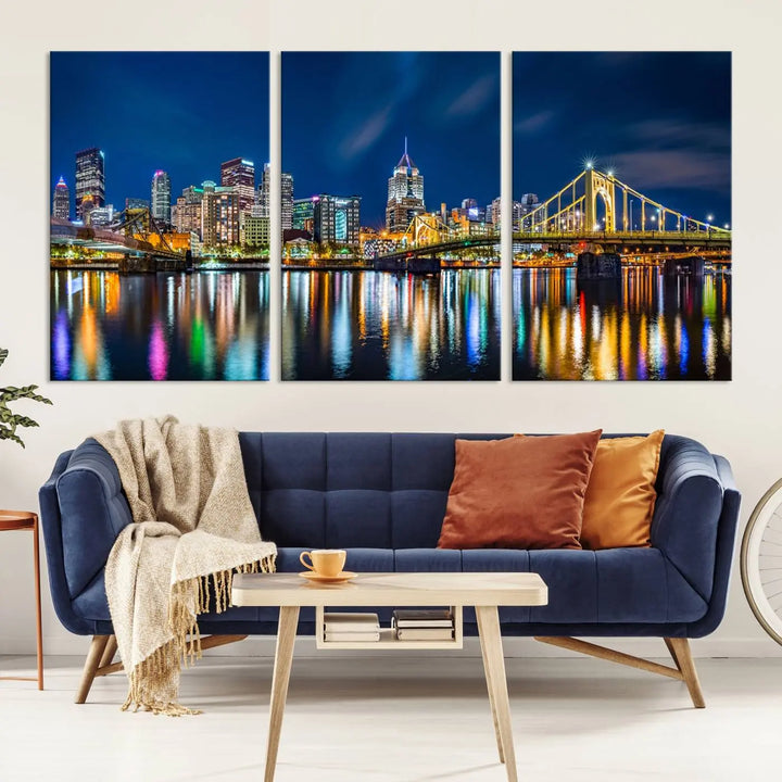 The living room features a gallery-wrapped triptych of Pittsburgh's skyline at night, reflecting on water. This Pittsburgh Skyline Canvas Wall Art is displayed above the cabinets and is printed on museum-quality canvas with a UV-protective coating to maintain its lasting vibrancy.