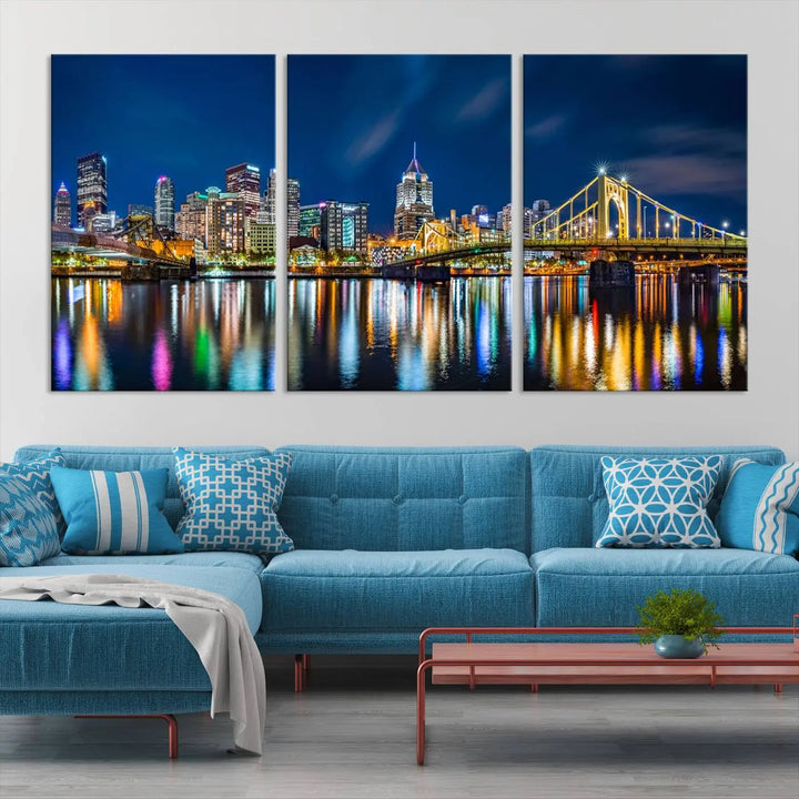 The living room features a gallery-wrapped triptych of Pittsburgh's skyline at night, reflecting on water. This Pittsburgh Skyline Canvas Wall Art is displayed above the cabinets and is printed on museum-quality canvas with a UV-protective coating to maintain its lasting vibrancy.