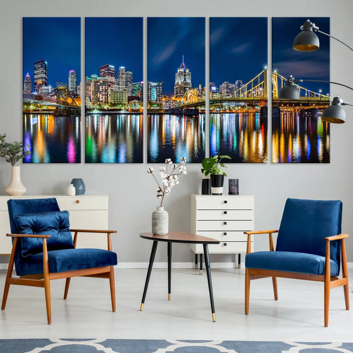 The living room features a gallery-wrapped triptych of Pittsburgh's skyline at night, reflecting on water. This Pittsburgh Skyline Canvas Wall Art is displayed above the cabinets and is printed on museum-quality canvas with a UV-protective coating to maintain its lasting vibrancy.