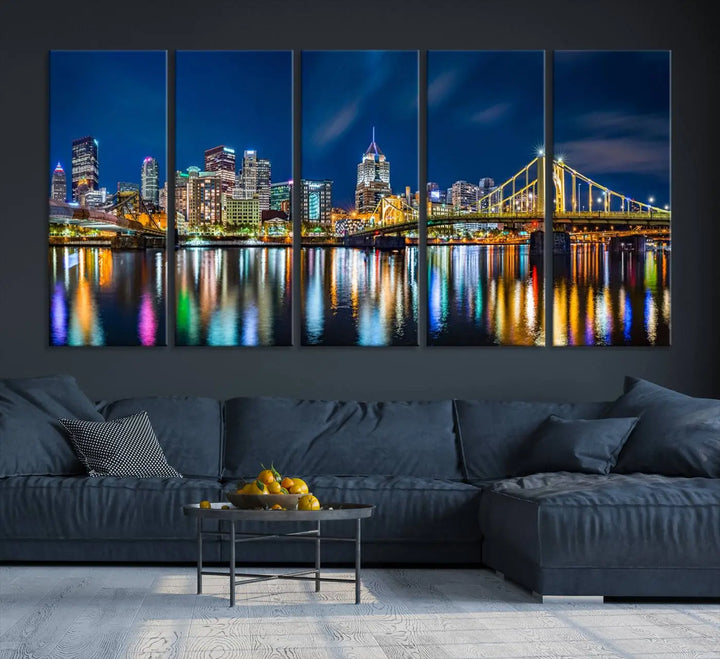 The living room features a gallery-wrapped triptych of Pittsburgh's skyline at night, reflecting on water. This Pittsburgh Skyline Canvas Wall Art is displayed above the cabinets and is printed on museum-quality canvas with a UV-protective coating to maintain its lasting vibrancy.