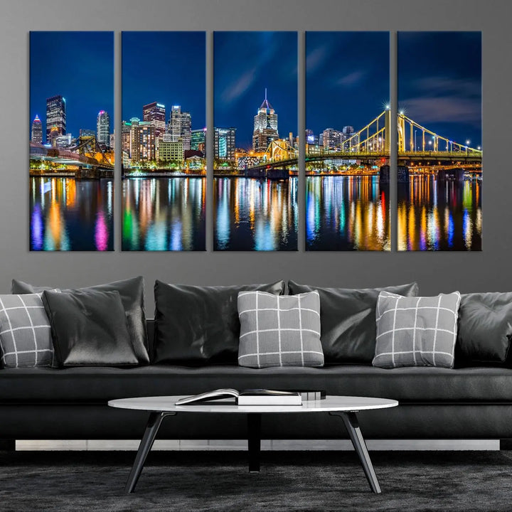 The living room features a gallery-wrapped triptych of Pittsburgh's skyline at night, reflecting on water. This Pittsburgh Skyline Canvas Wall Art is displayed above the cabinets and is printed on museum-quality canvas with a UV-protective coating to maintain its lasting vibrancy.