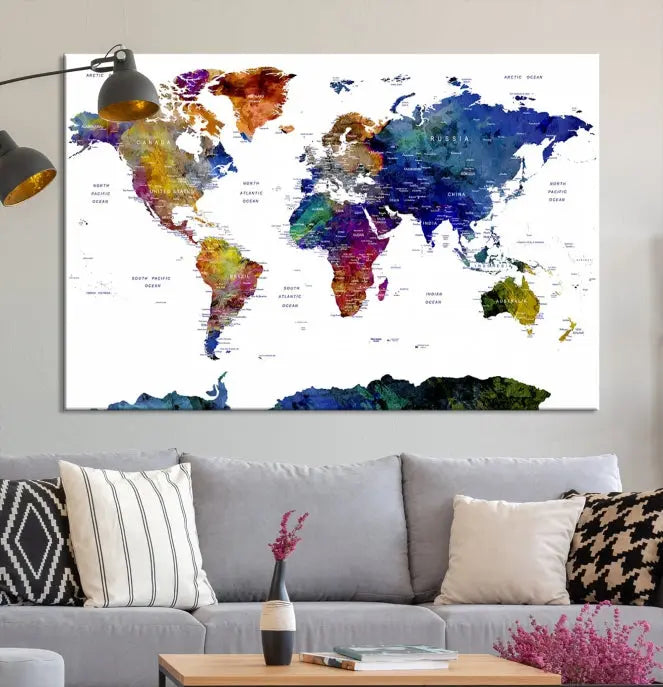 A modern living room is beautifully adorned with the Push Pin World Map Wall Art Canvas Print, a vibrant triptych of colorful world maps crafted on museum-quality canvas and perfectly gallery wrapped. This striking artwork stands out on its own, enhancing the room's overall aesthetics.