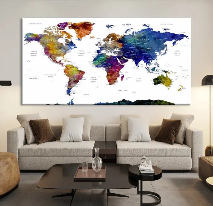 A modern living room is beautifully adorned with the Push Pin World Map Wall Art Canvas Print, a vibrant triptych of colorful world maps crafted on museum-quality canvas and perfectly gallery wrapped. This striking artwork stands out on its own, enhancing the room's overall aesthetics.