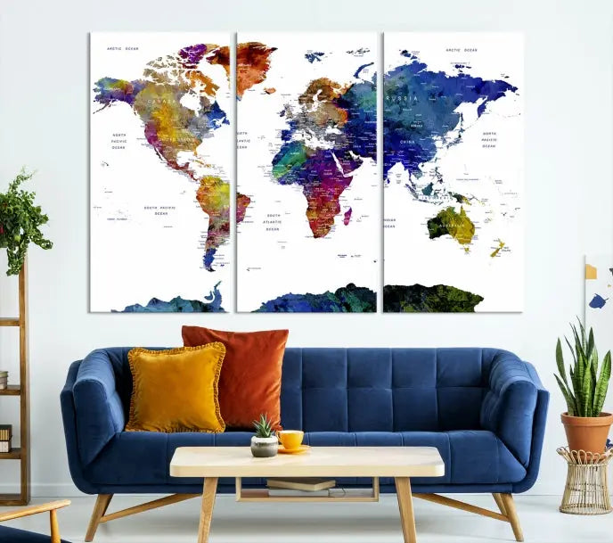 A modern living room is beautifully adorned with the Push Pin World Map Wall Art Canvas Print, a vibrant triptych of colorful world maps crafted on museum-quality canvas and perfectly gallery wrapped. This striking artwork stands out on its own, enhancing the room's overall aesthetics.