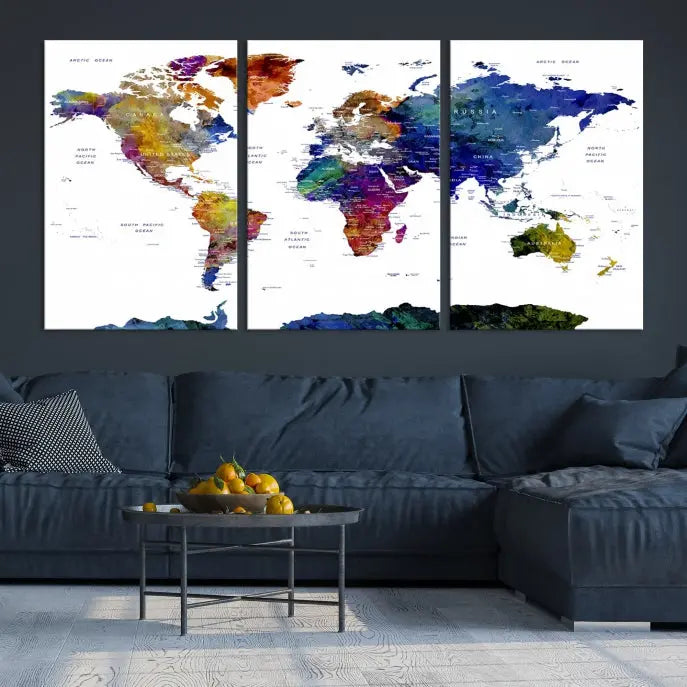 A modern living room is beautifully adorned with the Push Pin World Map Wall Art Canvas Print, a vibrant triptych of colorful world maps crafted on museum-quality canvas and perfectly gallery wrapped. This striking artwork stands out on its own, enhancing the room's overall aesthetics.