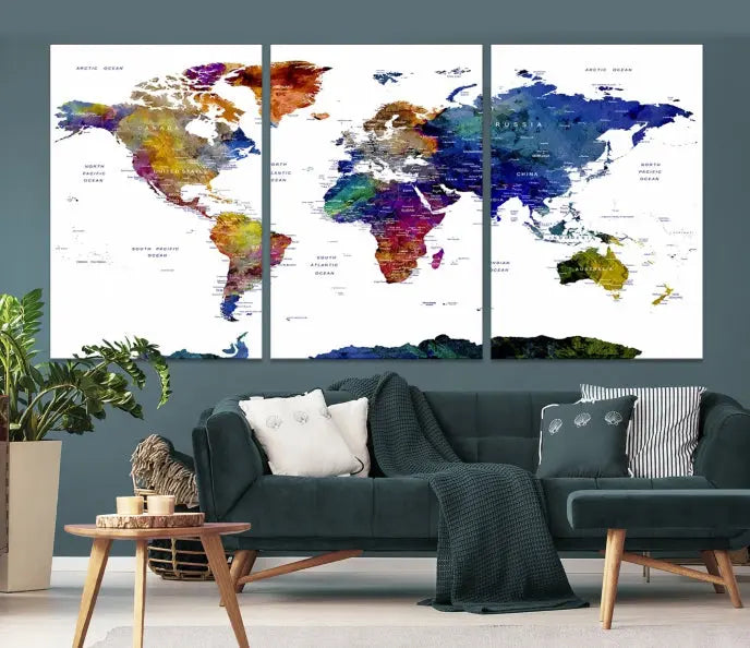 A modern living room is beautifully adorned with the Push Pin World Map Wall Art Canvas Print, a vibrant triptych of colorful world maps crafted on museum-quality canvas and perfectly gallery wrapped. This striking artwork stands out on its own, enhancing the room's overall aesthetics.