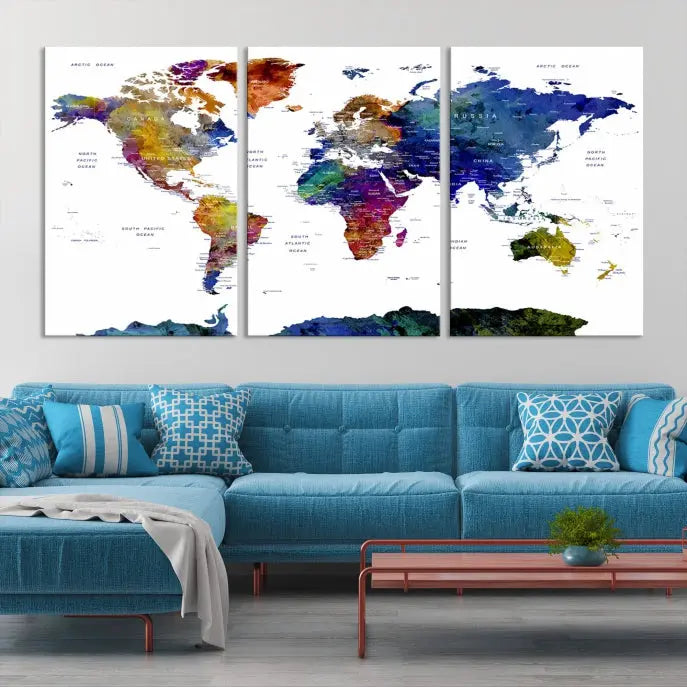 A modern living room is beautifully adorned with the Push Pin World Map Wall Art Canvas Print, a vibrant triptych of colorful world maps crafted on museum-quality canvas and perfectly gallery wrapped. This striking artwork stands out on its own, enhancing the room's overall aesthetics.