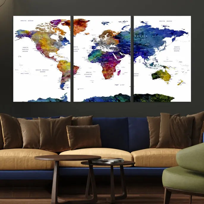 A modern living room is beautifully adorned with the Push Pin World Map Wall Art Canvas Print, a vibrant triptych of colorful world maps crafted on museum-quality canvas and perfectly gallery wrapped. This striking artwork stands out on its own, enhancing the room's overall aesthetics.