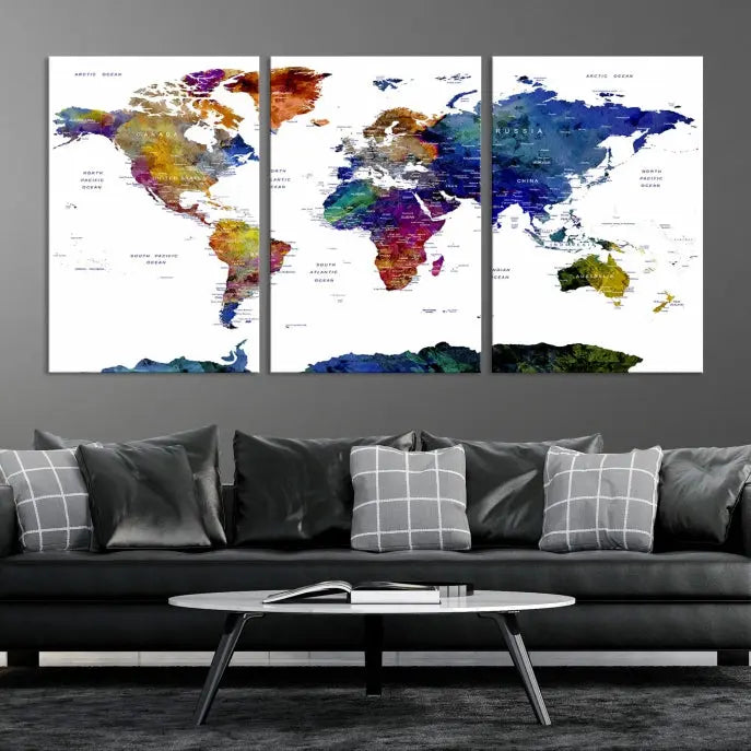 A modern living room is beautifully adorned with the Push Pin World Map Wall Art Canvas Print, a vibrant triptych of colorful world maps crafted on museum-quality canvas and perfectly gallery wrapped. This striking artwork stands out on its own, enhancing the room's overall aesthetics.