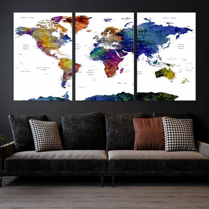 A modern living room is beautifully adorned with the Push Pin World Map Wall Art Canvas Print, a vibrant triptych of colorful world maps crafted on museum-quality canvas and perfectly gallery wrapped. This striking artwork stands out on its own, enhancing the room's overall aesthetics.