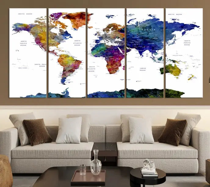 A modern living room is beautifully adorned with the Push Pin World Map Wall Art Canvas Print, a vibrant triptych of colorful world maps crafted on museum-quality canvas and perfectly gallery wrapped. This striking artwork stands out on its own, enhancing the room's overall aesthetics.