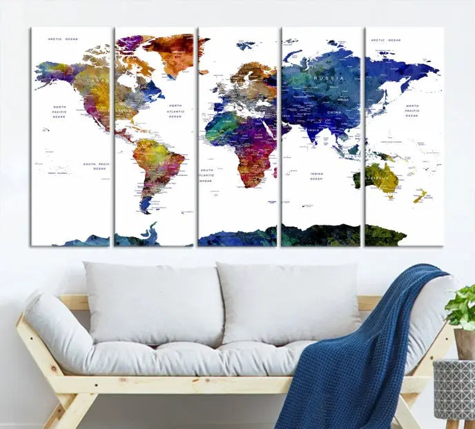 A modern living room is beautifully adorned with the Push Pin World Map Wall Art Canvas Print, a vibrant triptych of colorful world maps crafted on museum-quality canvas and perfectly gallery wrapped. This striking artwork stands out on its own, enhancing the room's overall aesthetics.