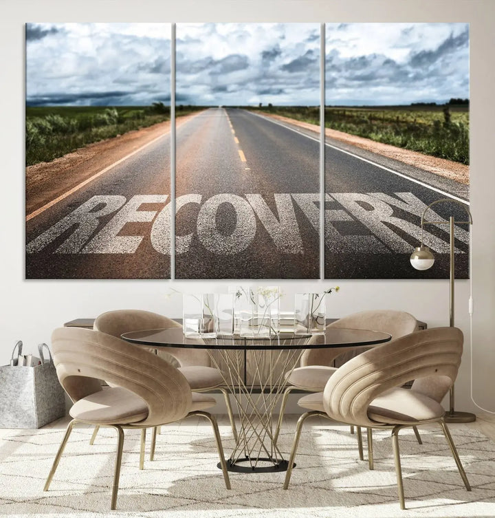 The Recovery Road Wall Art Canvas Print, a three-panel piece gallery wrapped on museum-quality canvas, displays an empty road with the word RECOVERY painted on it. This artwork is coated with UV-protection to maintain its vibrant colors over time.