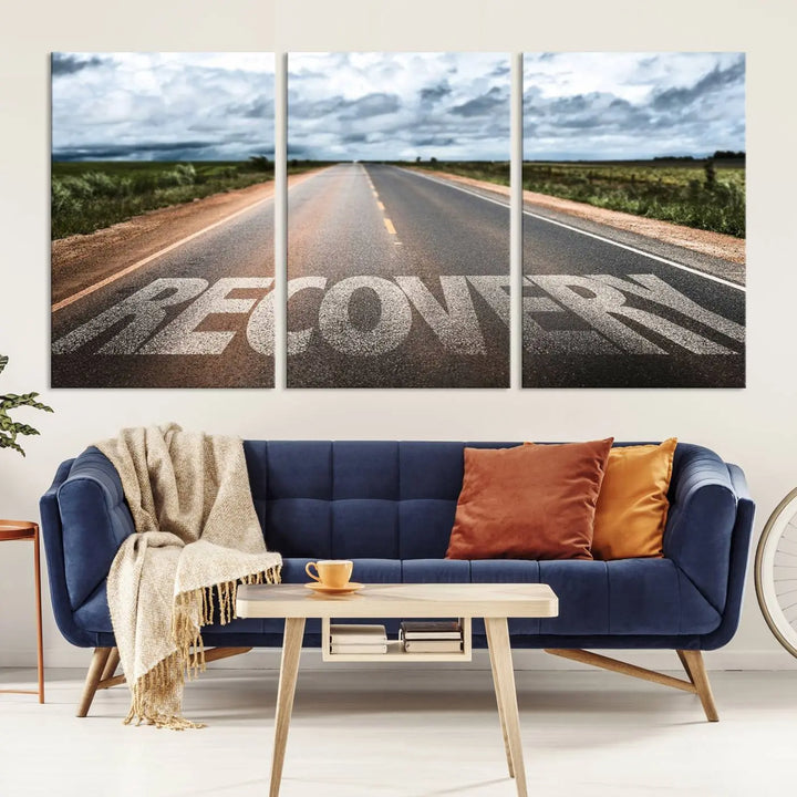 The Recovery Road Wall Art Canvas Print, a three-panel piece gallery wrapped on museum-quality canvas, displays an empty road with the word RECOVERY painted on it. This artwork is coated with UV-protection to maintain its vibrant colors over time.