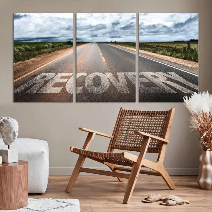 The Recovery Road Wall Art Canvas Print, a three-panel piece gallery wrapped on museum-quality canvas, displays an empty road with the word RECOVERY painted on it. This artwork is coated with UV-protection to maintain its vibrant colors over time.