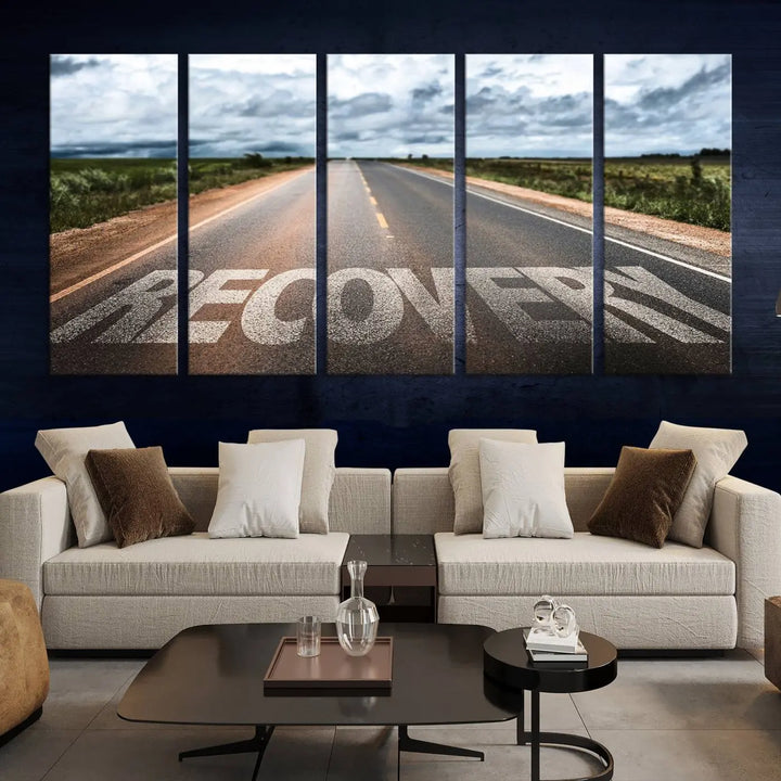 The Recovery Road Wall Art Canvas Print, a three-panel piece gallery wrapped on museum-quality canvas, displays an empty road with the word RECOVERY painted on it. This artwork is coated with UV-protection to maintain its vibrant colors over time.