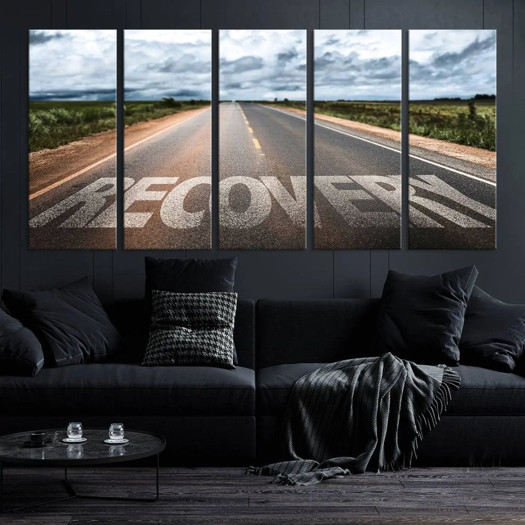 The Recovery Road Wall Art Canvas Print, a three-panel piece gallery wrapped on museum-quality canvas, displays an empty road with the word RECOVERY painted on it. This artwork is coated with UV-protection to maintain its vibrant colors over time.