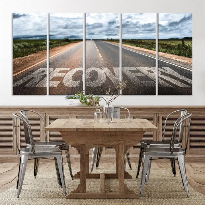 The Recovery Road Wall Art Canvas Print, a three-panel piece gallery wrapped on museum-quality canvas, displays an empty road with the word RECOVERY painted on it. This artwork is coated with UV-protection to maintain its vibrant colors over time.