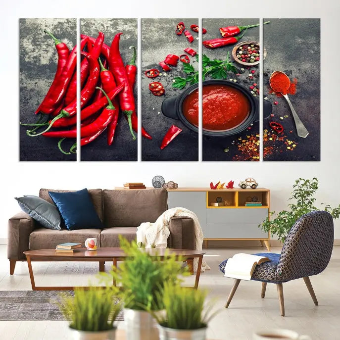 The Red Chili Peppers Wall Art Kitchen Artwork Canvas Print is a three-panel canvas showcasing red chili peppers, sliced chili, a pot of red sauce, and assorted spices on a dark background. It is of museum quality with a UV-protective coating to ensure its colors remain vibrant over time.