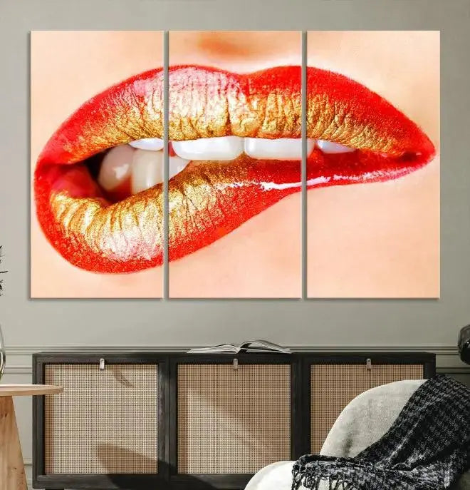 The Red Lip Bite Canvas Print, featuring a triptych of lips with red and gold lipstick, is elegantly displayed, enhancing the modern aesthetic of the minimalist room decor. This artwork is printed on high-quality polycotton canvas.