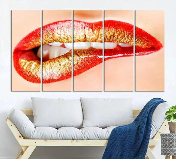 The Red Lip Bite Canvas Print, featuring a triptych of lips with red and gold lipstick, is elegantly displayed, enhancing the modern aesthetic of the minimalist room decor. This artwork is printed on high-quality polycotton canvas.