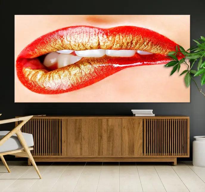 The Red Lip Bite Canvas Print, featuring a triptych of lips with red and gold lipstick, is elegantly displayed, enhancing the modern aesthetic of the minimalist room decor. This artwork is printed on high-quality polycotton canvas.