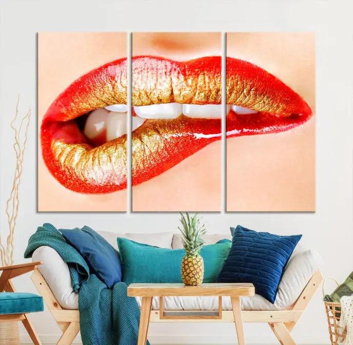 The Red Lip Bite Canvas Print, featuring a triptych of lips with red and gold lipstick, is elegantly displayed, enhancing the modern aesthetic of the minimalist room decor. This artwork is printed on high-quality polycotton canvas.