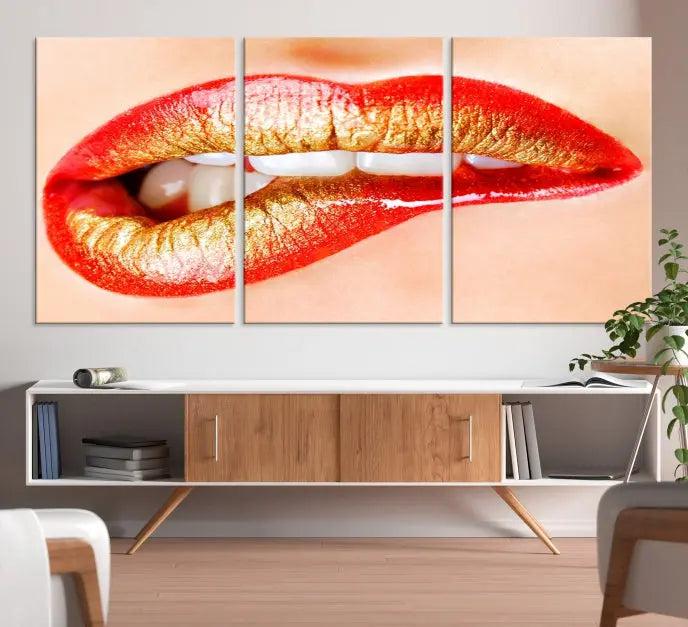 The Red Lip Bite Canvas Print, featuring a triptych of lips with red and gold lipstick, is elegantly displayed, enhancing the modern aesthetic of the minimalist room decor. This artwork is printed on high-quality polycotton canvas.