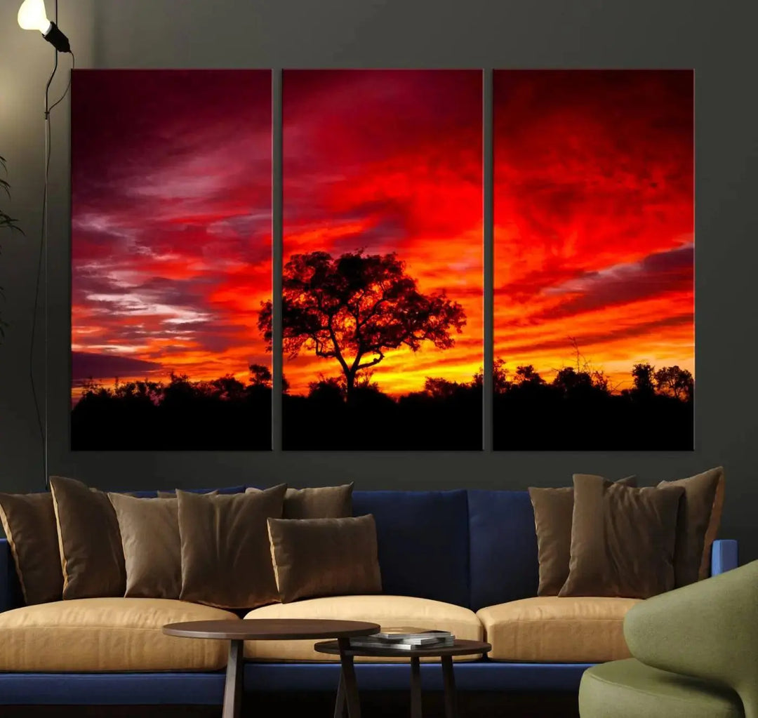 The living room features a hand-assembled triptych of the Red Sunset Landscape Artwork Printing, showing a fiery sunset over a forest tree. This piece, printed on museum-quality canvas, adds an artistic touch to the space.