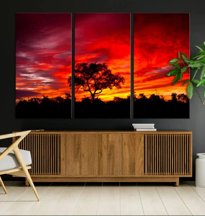 The living room features a hand-assembled triptych of the Red Sunset Landscape Artwork Printing, showing a fiery sunset over a forest tree. This piece, printed on museum-quality canvas, adds an artistic touch to the space.