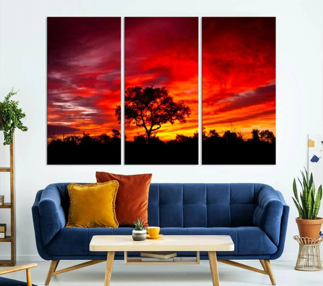 The living room features a hand-assembled triptych of the Red Sunset Landscape Artwork Printing, showing a fiery sunset over a forest tree. This piece, printed on museum-quality canvas, adds an artistic touch to the space.