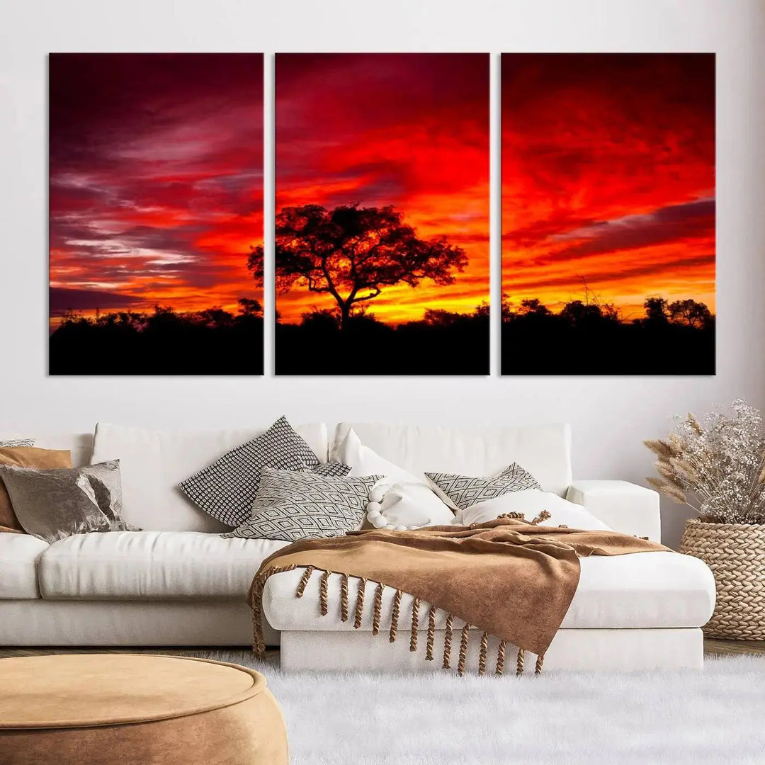 The living room features a hand-assembled triptych of the Red Sunset Landscape Artwork Printing, showing a fiery sunset over a forest tree. This piece, printed on museum-quality canvas, adds an artistic touch to the space.