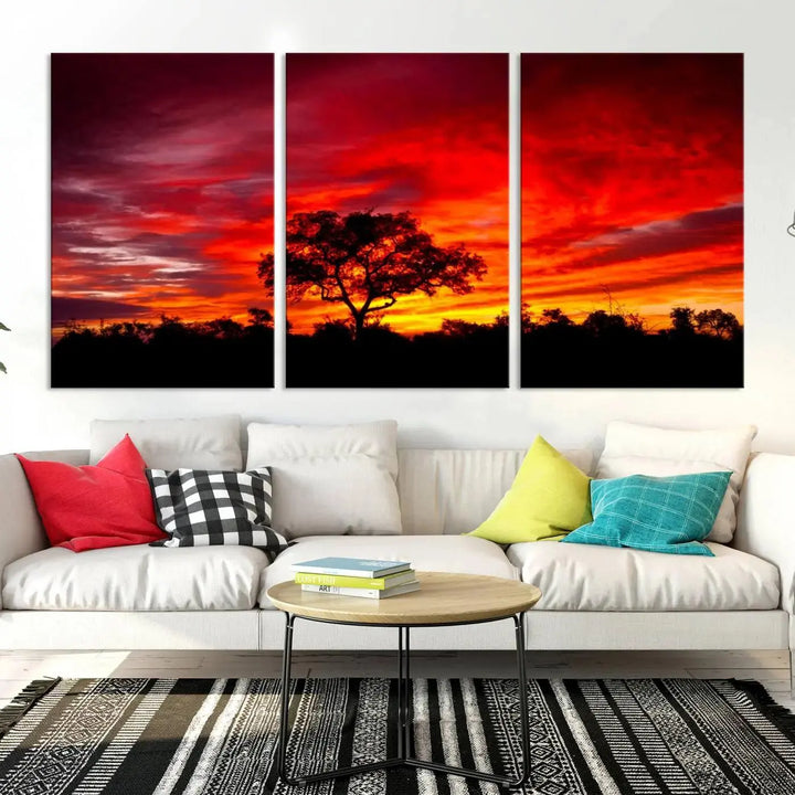 The living room features a hand-assembled triptych of the Red Sunset Landscape Artwork Printing, showing a fiery sunset over a forest tree. This piece, printed on museum-quality canvas, adds an artistic touch to the space.