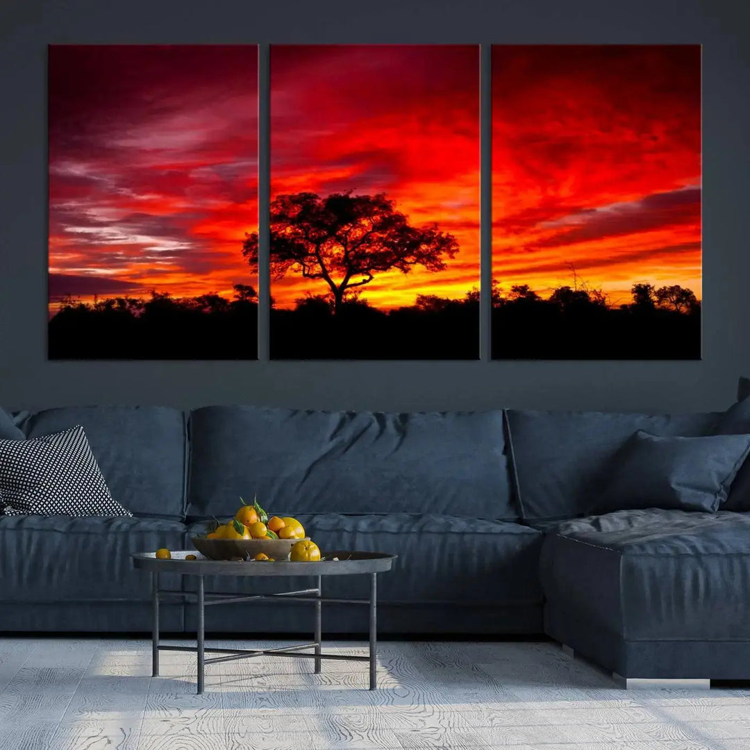 The living room features a hand-assembled triptych of the Red Sunset Landscape Artwork Printing, showing a fiery sunset over a forest tree. This piece, printed on museum-quality canvas, adds an artistic touch to the space.