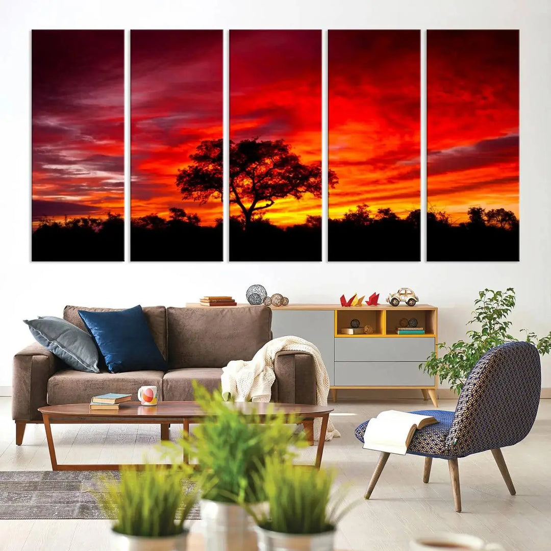 The living room features a hand-assembled triptych of the Red Sunset Landscape Artwork Printing, showing a fiery sunset over a forest tree. This piece, printed on museum-quality canvas, adds an artistic touch to the space.