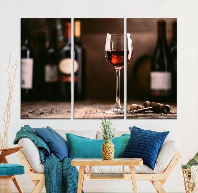 The "Red Wine and Bottle Canvas Print" is a triptych on museum-quality canvas, featuring a glass of red wine with subtle depictions of wine bottles and corks in the background, all beautifully gallery wrapped.