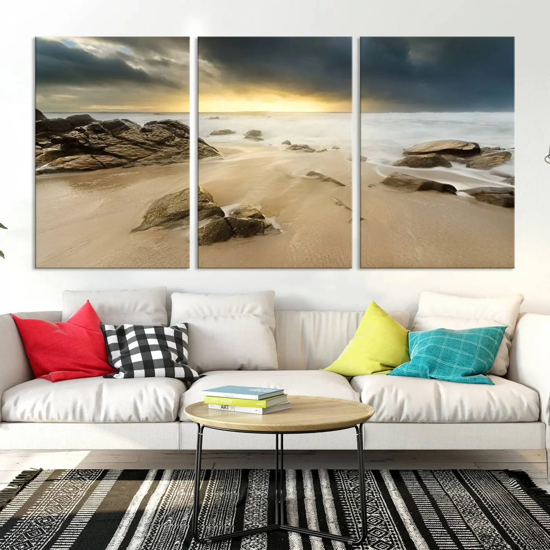 A gallery-wrapped, three-panel artwork titled "Rocks and Waves Wall Art Canvas Print" depicts a rocky beach at sunset. Each canvas showcases museum-quality craftsmanship and a UV-protective coating to maintain its vibrant colors.