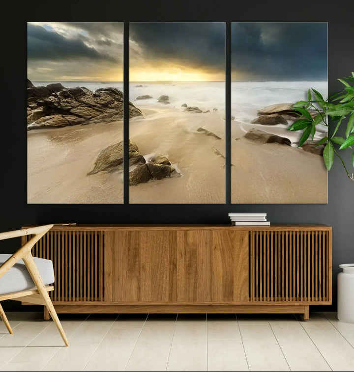 A gallery-wrapped, three-panel artwork titled "Rocks and Waves Wall Art Canvas Print" depicts a rocky beach at sunset. Each canvas showcases museum-quality craftsmanship and a UV-protective coating to maintain its vibrant colors.