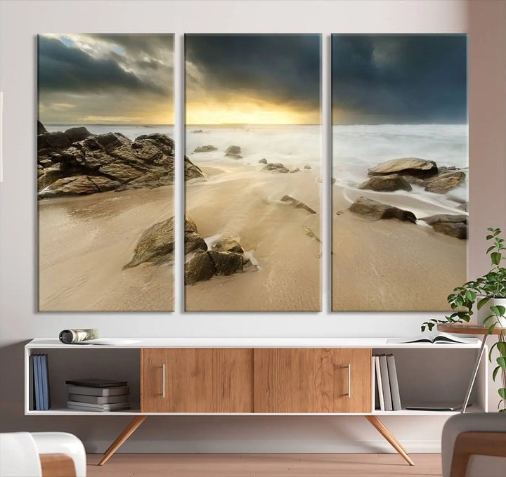 A gallery-wrapped, three-panel artwork titled "Rocks and Waves Wall Art Canvas Print" depicts a rocky beach at sunset. Each canvas showcases museum-quality craftsmanship and a UV-protective coating to maintain its vibrant colors.