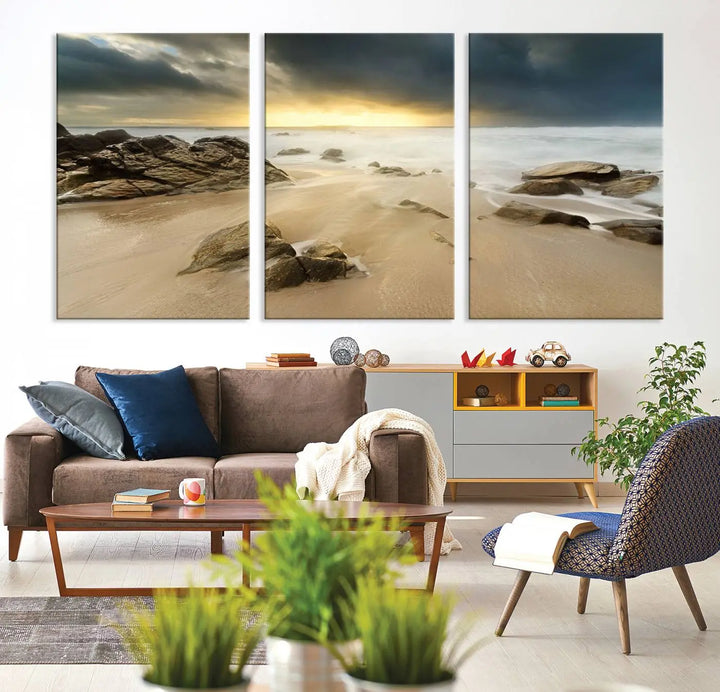 A gallery-wrapped, three-panel artwork titled "Rocks and Waves Wall Art Canvas Print" depicts a rocky beach at sunset. Each canvas showcases museum-quality craftsmanship and a UV-protective coating to maintain its vibrant colors.