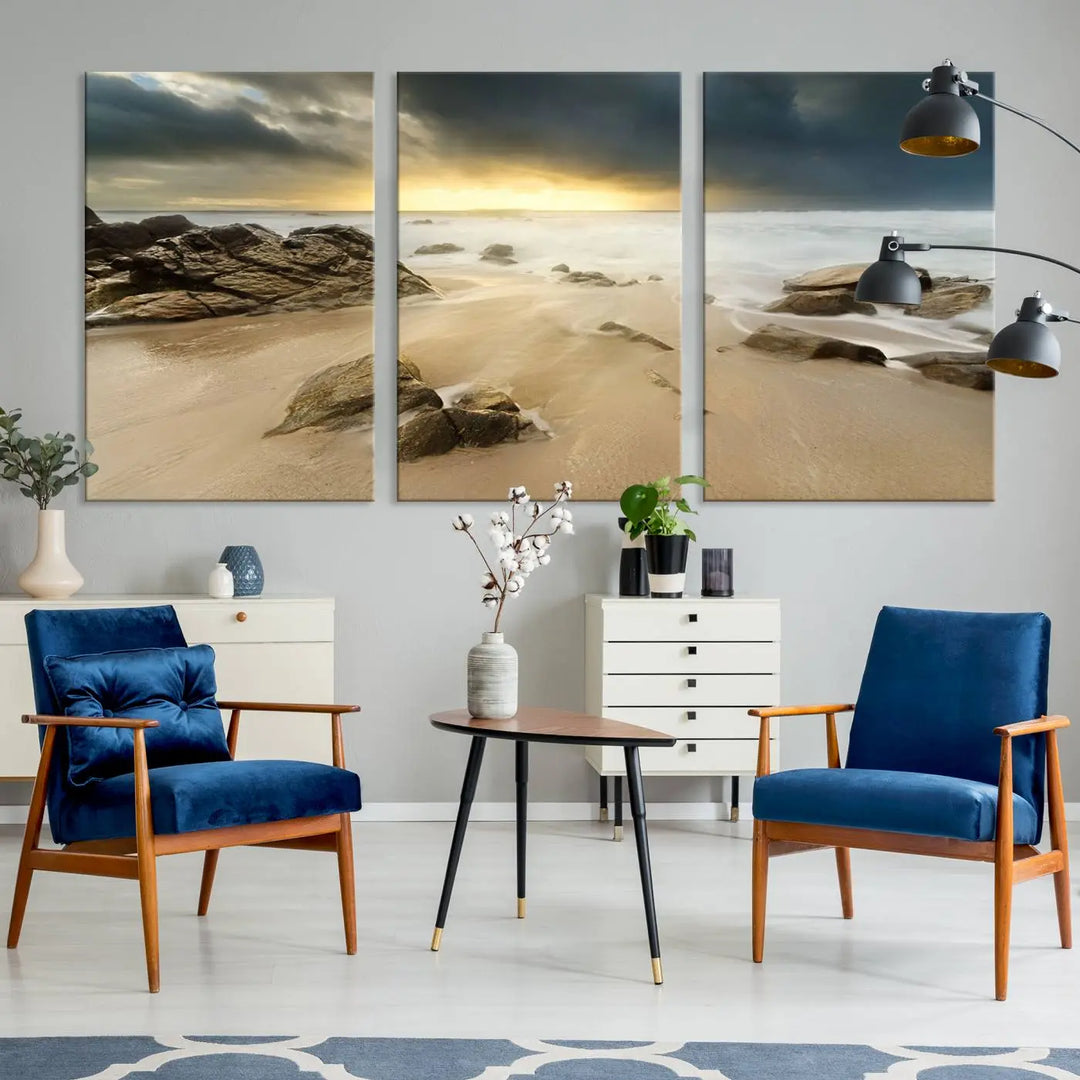 A gallery-wrapped, three-panel artwork titled "Rocks and Waves Wall Art Canvas Print" depicts a rocky beach at sunset. Each canvas showcases museum-quality craftsmanship and a UV-protective coating to maintain its vibrant colors.