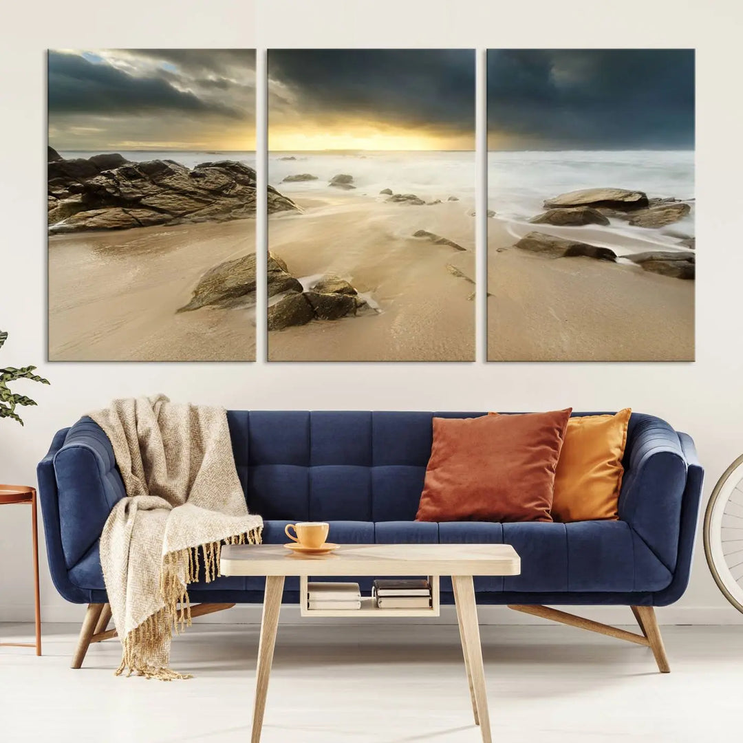 A gallery-wrapped, three-panel artwork titled "Rocks and Waves Wall Art Canvas Print" depicts a rocky beach at sunset. Each canvas showcases museum-quality craftsmanship and a UV-protective coating to maintain its vibrant colors.