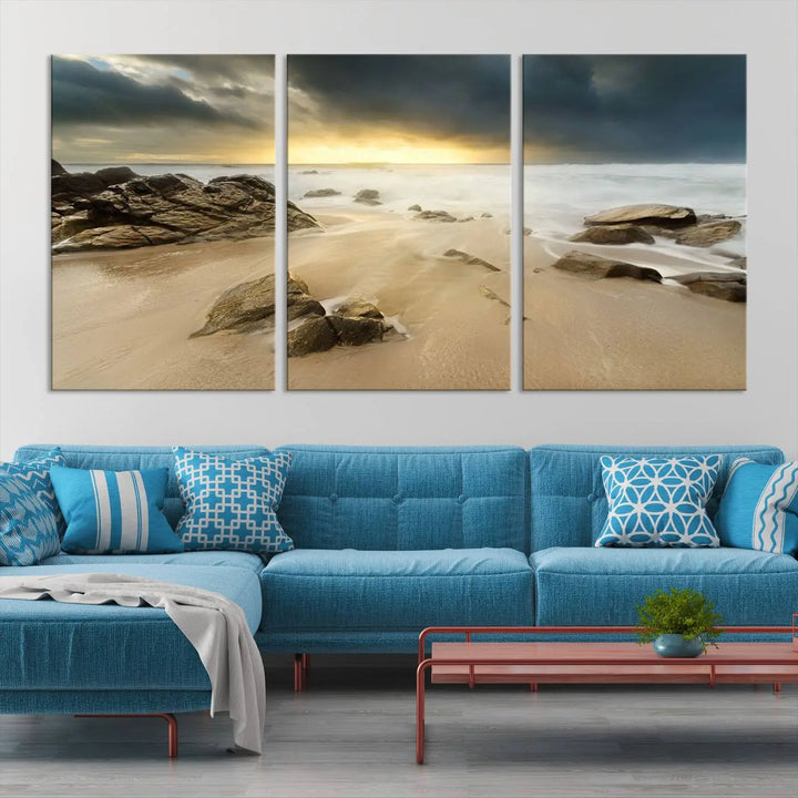 A gallery-wrapped, three-panel artwork titled "Rocks and Waves Wall Art Canvas Print" depicts a rocky beach at sunset. Each canvas showcases museum-quality craftsmanship and a UV-protective coating to maintain its vibrant colors.