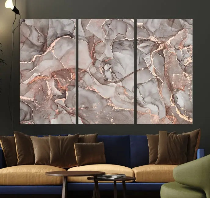 The Rose Gold Marble Fluid Effect Wall Art Abstract Canvas Wall Art Print is an exquisite three-panel creation crafted on museum-quality canvas. It features swirling marbled patterns in shades of gray, copper, and beige. Complete with a UV-protective coating, this ready-to-hang artwork promises to be a timeless addition to any space.