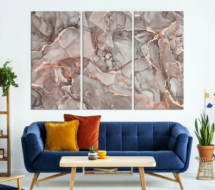 The Rose Gold Marble Fluid Effect Wall Art Abstract Canvas Wall Art Print is an exquisite three-panel creation crafted on museum-quality canvas. It features swirling marbled patterns in shades of gray, copper, and beige. Complete with a UV-protective coating, this ready-to-hang artwork promises to be a timeless addition to any space.